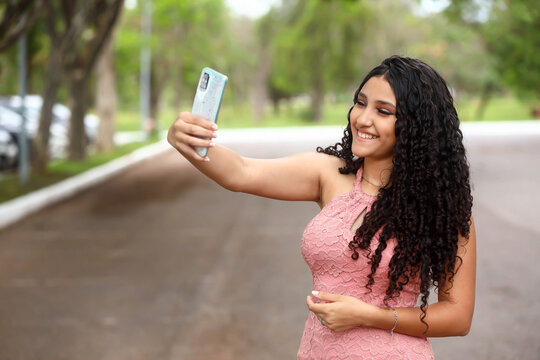 girl taking selfie by cell phone, latina, happy, smartphone, front-facing camera, social media, Instagram