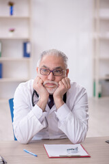 Old male doctor working in the clinic