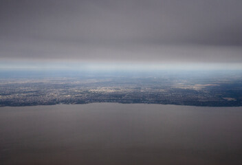 Traveling to Buenos Aires. View of the Rio de la Plata, coastline and city seen from very high in the sky. 