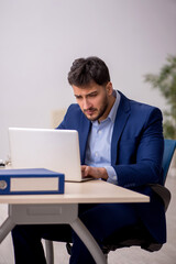 Young male employee sitting at workplace