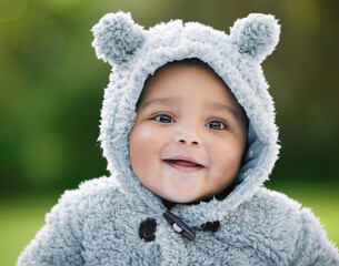 Dont you just wanna cuddle this cutie. Portrait of an adorable baby boy wearing a furry jacket with bear ears outdoors.