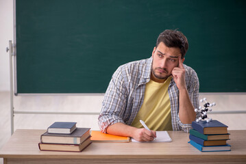 Young male physicist student in the classroom