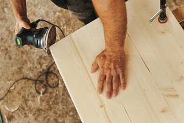 Detat him of the carpenter's sanding hands.