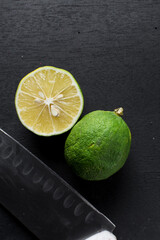 Top view of sliced green limes on a dark background, Flat lay of organic green limes