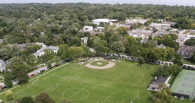 Aerial view of a soccer and baseball field with children playing near the downtown section of Glencoe, IL.