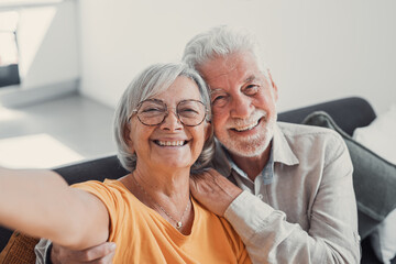 Head shot portrait happy senior couple taking selfie, having fun with phone cam, smiling aged wife and husband hugging, looking at camera, posing for photo, aged man vlogger recording video.