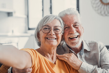 Head shot portrait happy senior couple taking selfie, having fun with phone cam, smiling aged wife...