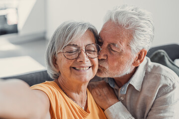 Head shot portrait happy senior couple taking selfie, having fun with phone cam, smiling aged wife and husband hugging, looking at camera, posing for photo, aged man vlogger recording video.
