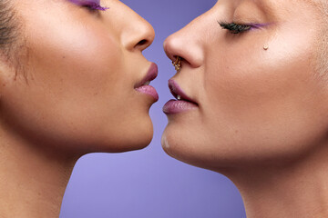 Up close and purple. Cropped shot of two young women wearing purple make-up.