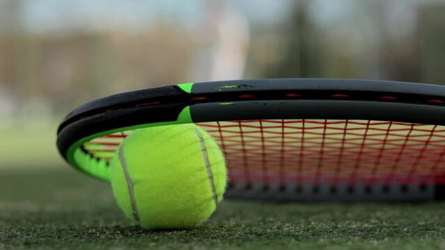 Close-up of a green tennis ball with a racket for playing on the court. Sport, game concept. Training in the background. big tournament.