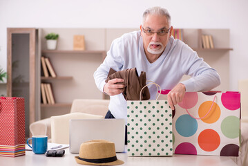 Old man with many bags in Christmas concept at home