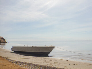 Quiet Seaside with Lone Boat on Shore and Spectacular Blue Sky with Cirrus Clouds