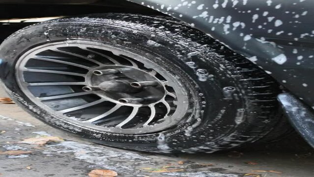 hands of a person washing a vehicle wheel