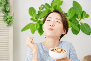 自宅でナッツを食べる女性