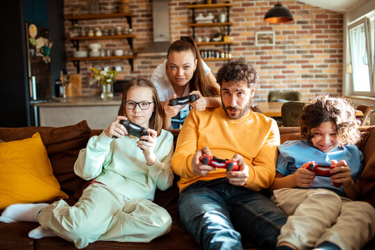 Young family playing video games together in the living room on a gaming console