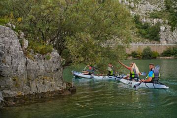 A group of friends enjoying having fun and kayaking while exploring the calm river, surrounding forest and large natural river canyons
