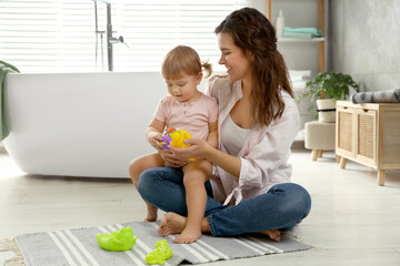 Mother playing with her daughter in bathroom