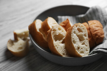 Fresh crispy ciabattas on white wooden table, closeup