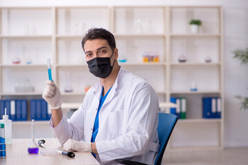 Young male chemist working at the lab