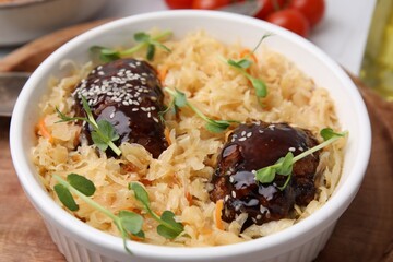 Bowl with sauerkraut and chicken on table, closeup