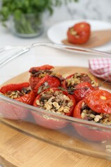 Delicious stuffed tomatoes with minced beef, bulgur and mushrooms in glass baking dish, closeup