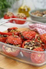 Delicious stuffed tomatoes with minced beef, bulgur and mushrooms in glass baking dish, closeup