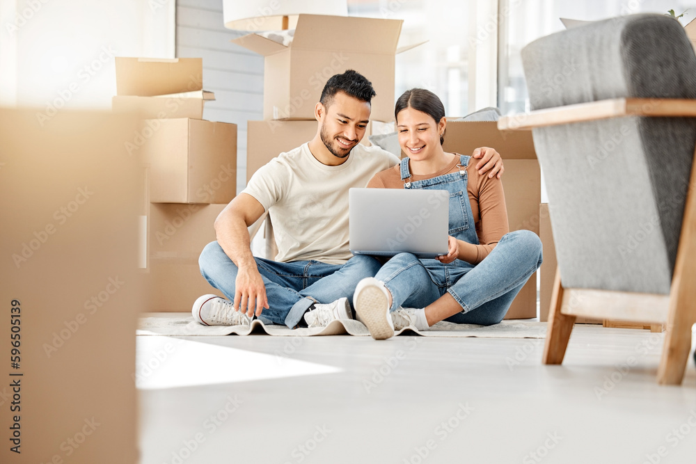 Canvas Prints Lets see what furniture we can buy online. Shot of a young couple using a laptop while moving house.