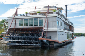 Fototapeta na wymiar A view of a historic building in the shape of a steamship from a water taxi on Lake Buna Vista. The building is a seafood restaurant with outdoor seating and a rooftop bar. 