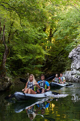 A group of friends enjoying having fun and kayaking while exploring the calm river, surrounding forest and large natural river canyons