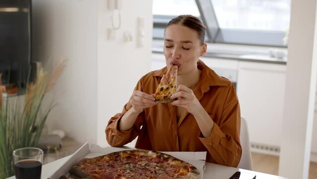 Bad food delivery. Young woman anticipating meal and biting pizza but feeling disatisfaction, feeling displeased