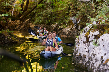 A group of friends enjoying having fun and kayaking while exploring the calm river, surrounding forest and large natural river canyons