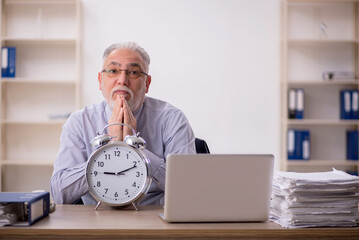 Old male employee in time management concept