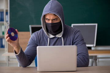 Young male hacker sitting in the classroom