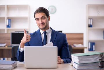 Young male employee and too much work in the office