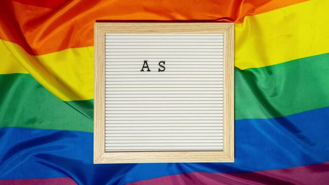 Stop motion of ASK MY PRONOUNS text Neo pronouns concept on Rainbow flag background gender pronouns. Non-binary people rights transgenders. Lgbtq community support assume my gender, respect pronouns