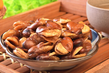 Roasted salted broad beans on a plate on wooden table