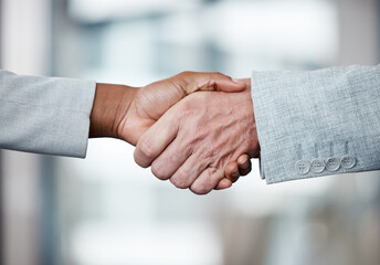 Weve made a deal. Shot of two unrecognizable businespeople shaking hands in an office at work.