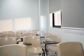 Empty classes at university or school with chairs and side tables, the chairs are arranged in rows.