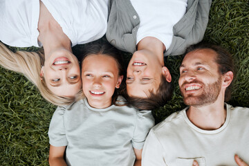 All that everyone wants is a happy family. Shot of a young couple lying outside with their two children.