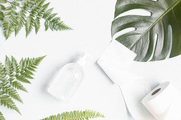 Skin care concept with white bottle and palm leaves on tropical background.