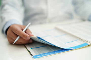 Asian man doctor study document to research method and technic for treating patients.