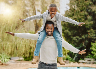 Flying high with dad. Cropped portrait of an adorable little boy sitting on his fathers shoulders...
