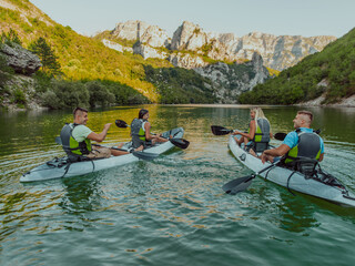 A group of friends enjoying having fun and kayaking while exploring the calm river, surrounding forest and large natural river canyons