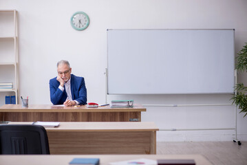 Old male teacher in the classroom