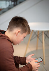 Teenager with a smartphone. In the hands of a touch phone. WiFi. Correspondence in messengers. Internet.