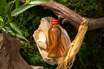 Top view of glass transparent bottle filled with herbal medicine displayed on a stone. Ginseng...