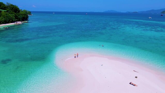 North point beach a sand bar at Koh Lipe Island Satun Thailand. A couple of men and women walking on a sandbank in the blue ocean of Ko Lipe