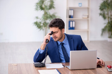 Young male employee and too much work in the office