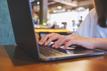 Closeup image of hands working and typing on laptop computer keyboard