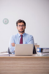 Young male employee sitting in the office